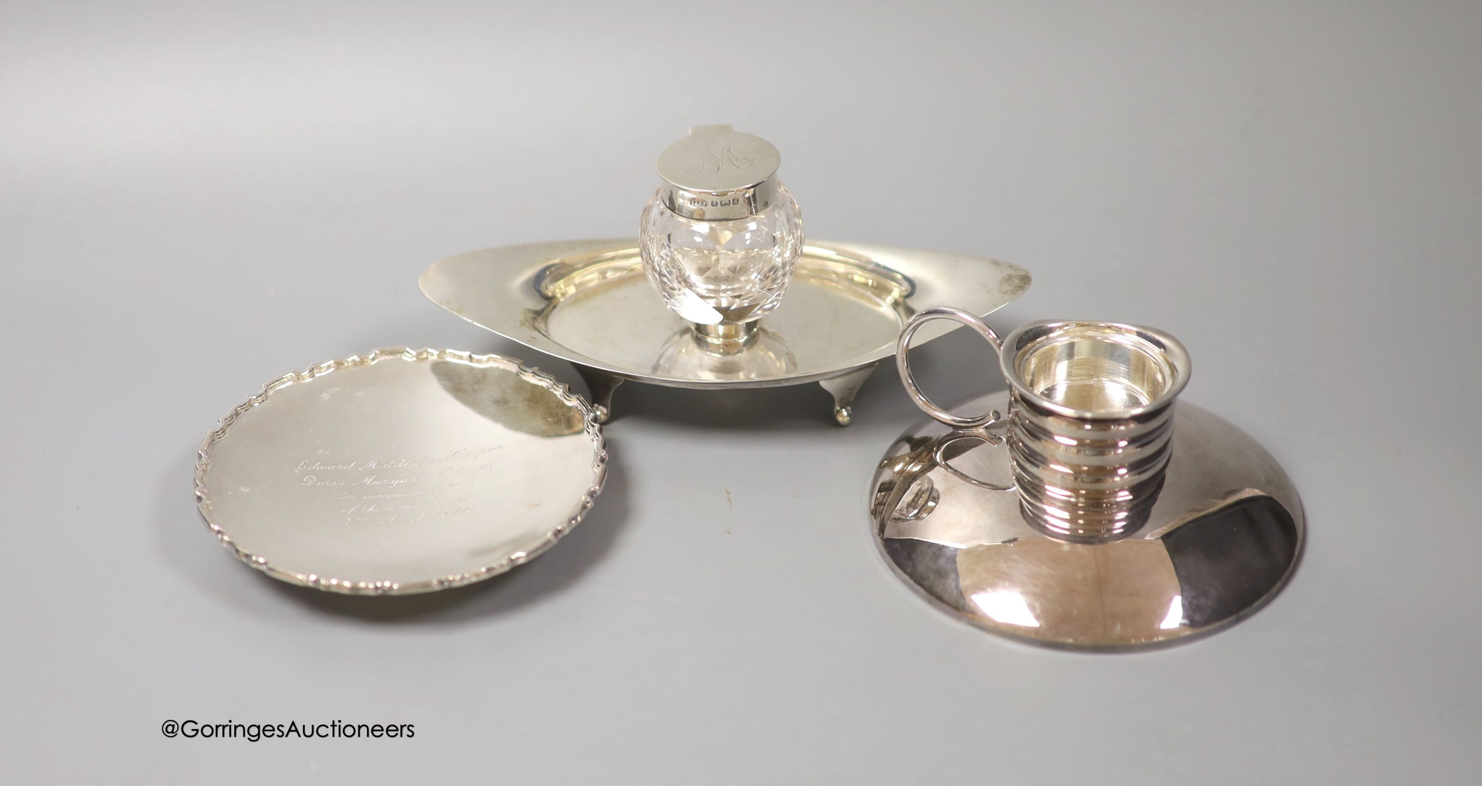An Edwardian silver navette shaped inkstand, with single well, Birmingham, 1903, 17.5cm, a small modern silver presentation dish and an early 20th century German 835s white metal mounted chamberstick, by Gayer & Krauss.